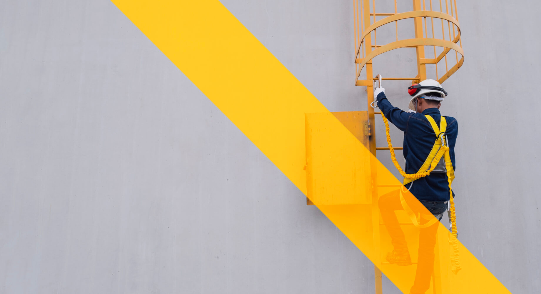 Man climbing ladders with safety harness