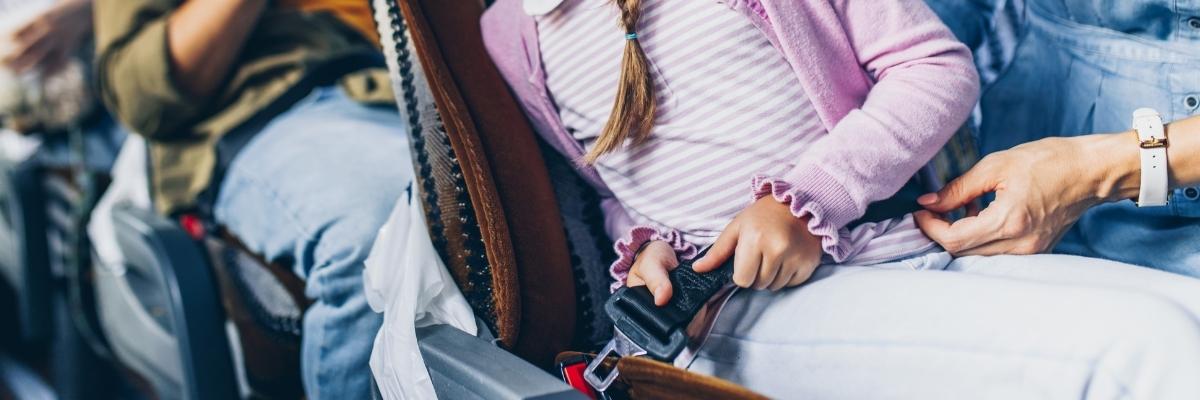 girl putting on her bus seat belt